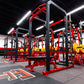 Commercial gym flooring with red and black rubber tiles installed in modern fitness facility with red weight racks