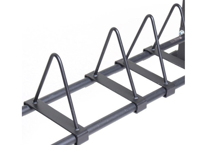 Black metal bumper storage rack with four vertical cradles on horizontal bar, mounted on white background