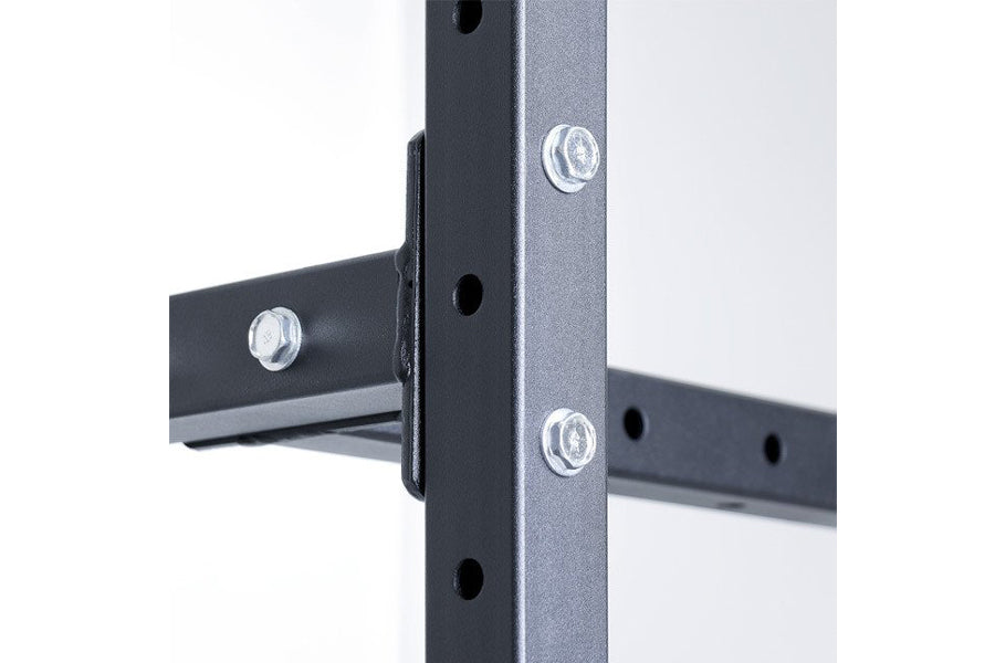 Black steel vertical storage rack with adjustable pegs and metal fasteners, close-up on white background
