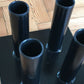 Warrior Vertical Floor 4 Olympic Bar Holder with four black steel tubes mounted on black base, on wooden floor
