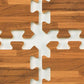 Brown wood grain interlocking foam floor tiles with white puzzle-piece edges, flat lay on wood surface