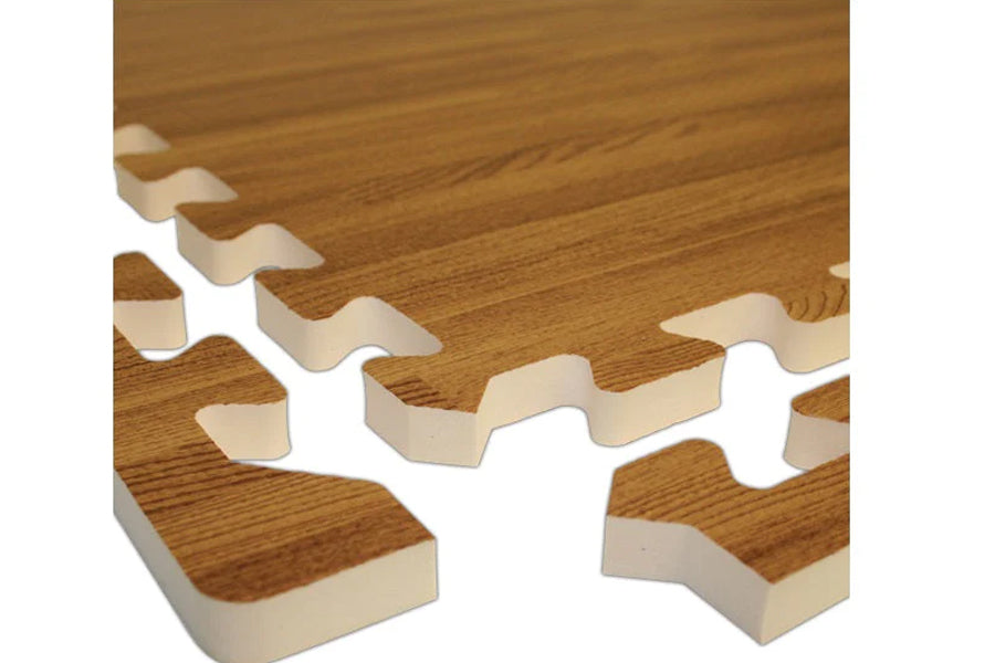 Interlocking foam gym floor tiles with wood grain pattern, tan and brown color, puzzle-style edges on white background