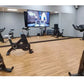 Warrior Wood Grain Interlocking Gym Flooring Tiles in light oak finish shown in fitness studio with stationary bikes
