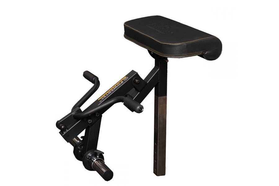 Black stationary exercise machine with padded seat and adjustable leg curl attachment on white background