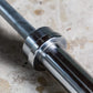 York Elite Power Bar with chrome collar and black grip sleeve on concrete surface