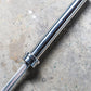 York Elite Power Bar in polished chrome with knurled grip section, flat lay on concrete surface