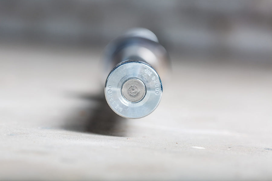 Silver metal Olympic barbell end cap with circular center design, shown from front view on white surface
