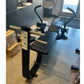 Black commercial abdominal bench with padded seat and backrest, gold metal frame, black handles, in gym setting with cardboar