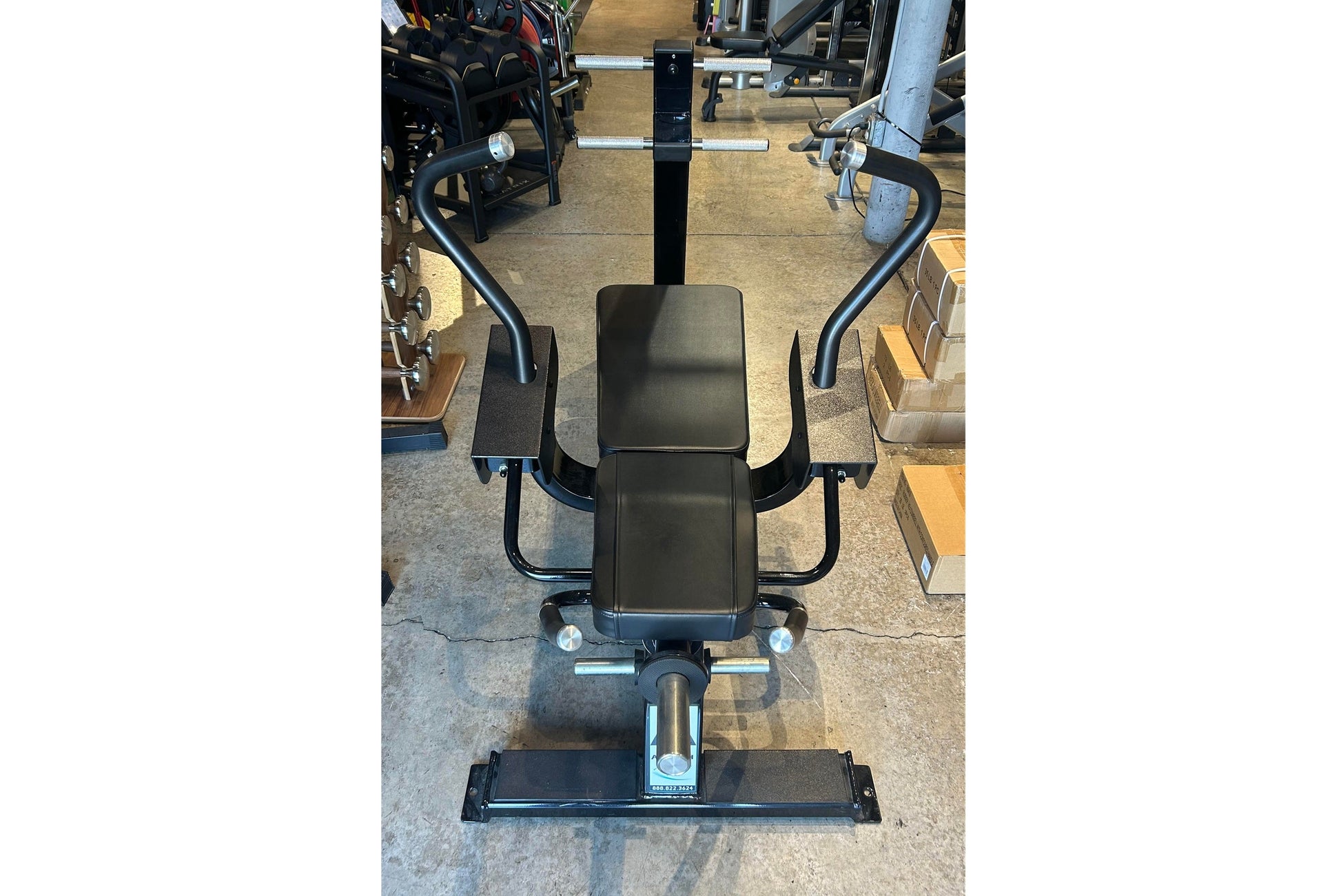 Black commercial ab bench with curved handlebars and padded seat, viewed from above in showroom setting
