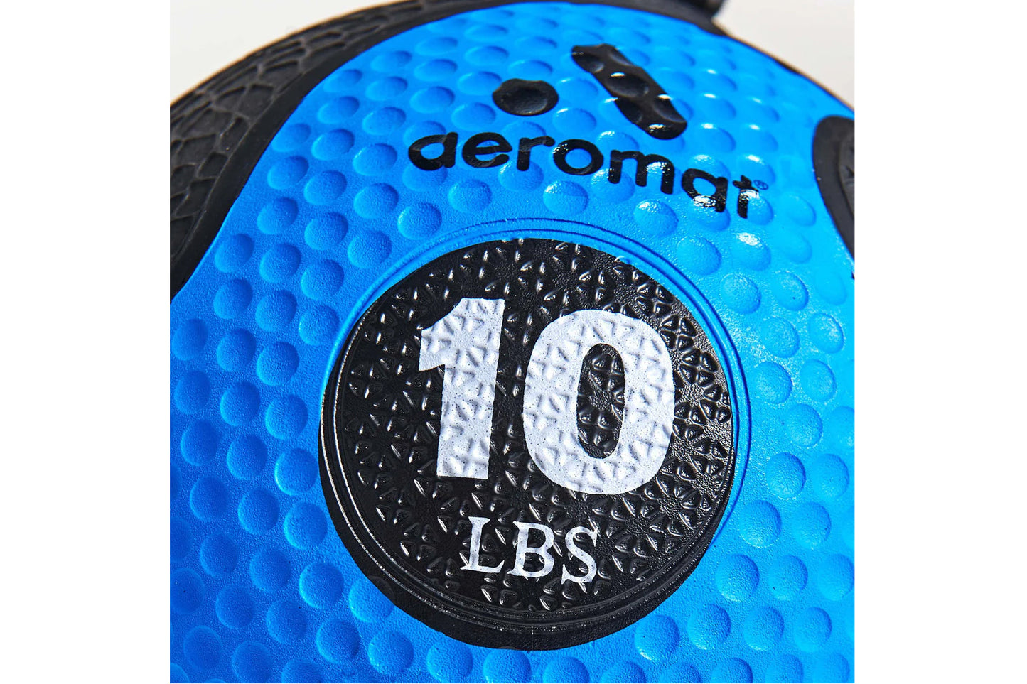 Bright blue medicine ball with textured grip surface, black circular weight marking reading "10 LBS" with Aeromat branding vi