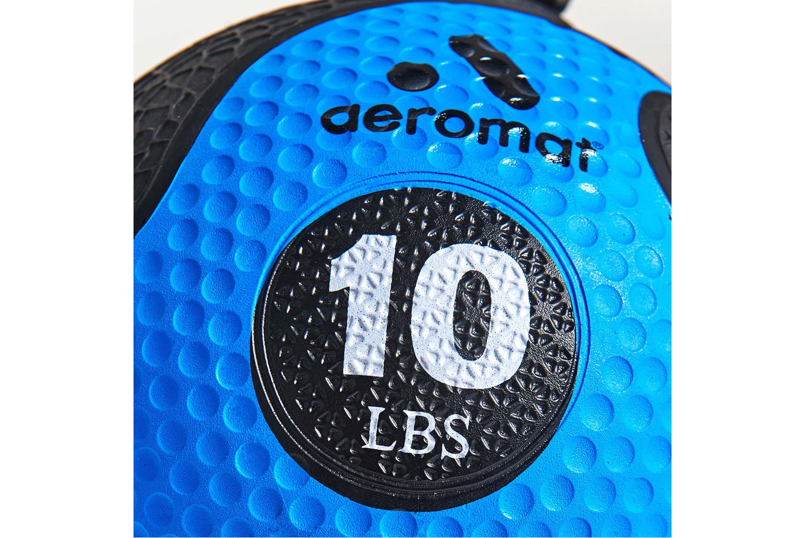 Bright blue medicine ball with textured grip surface, black circular weight marking reading "10 LBS" with Aeromat branding vi