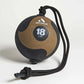 Aeromat 18 lbs medicine ball with tan textured surface, black trim, and black rope attachment on white background