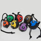 Set of seven medicine balls with rope handles in assorted colors including orange, green, red, yellow, purple, brown, and blu