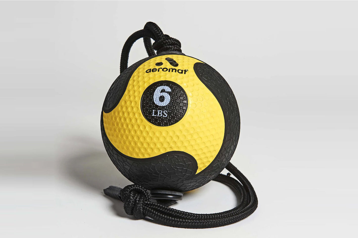 Yellow and black textured medicine ball with 6 LBS weight indicator, black braided rope handles, displayed on white backgroun