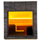 Almost Heaven Alpina outdoor sauna with dark wood exterior, glass door window, and glowing yellow-orange interior lighting sh