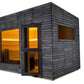 Almost Heaven Alpina outdoor sauna with dark stained wood exterior, illuminated golden interior visible through glass door an