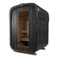 Black wood outdoor sauna with curved top, glass door showing cedar interior, and wooden base on white background