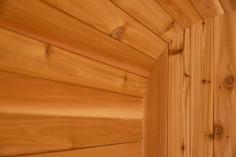 Interior view of cedar wood sauna with horizontal tongue-and-groove walls and exposed beam ceiling