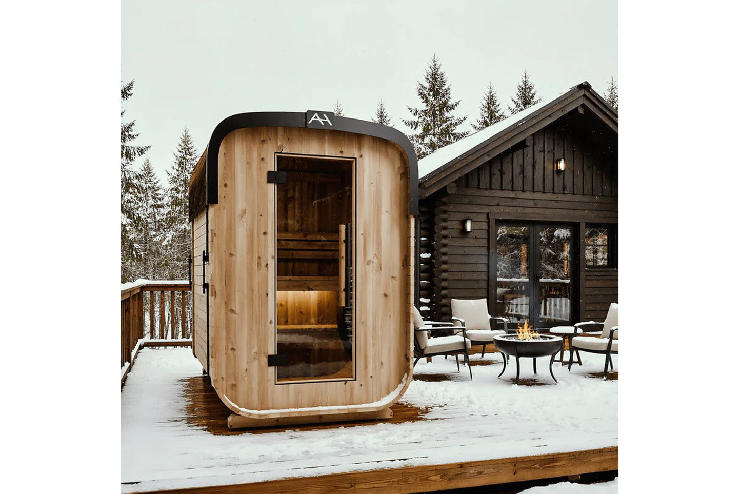 Almost Heaven Blackwater wooden outdoor sauna with curved cedar exterior and glass door in snowy alpine setting