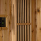 Cedar wood sauna interior with digital dual control panels, vertical wood slats, and ventilation holes mounted on wooden wall