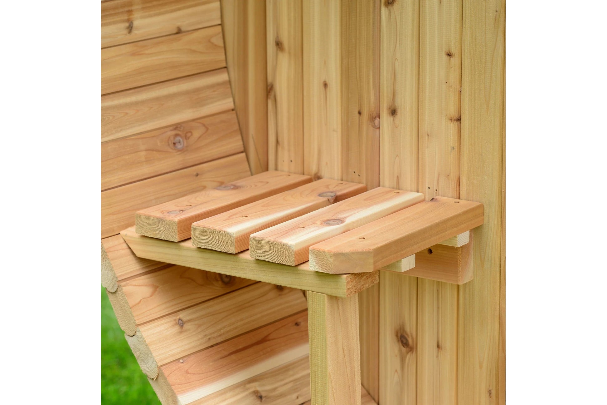 Natural wood sauna interior with wooden bench seating and backrest rails inside cedar structure