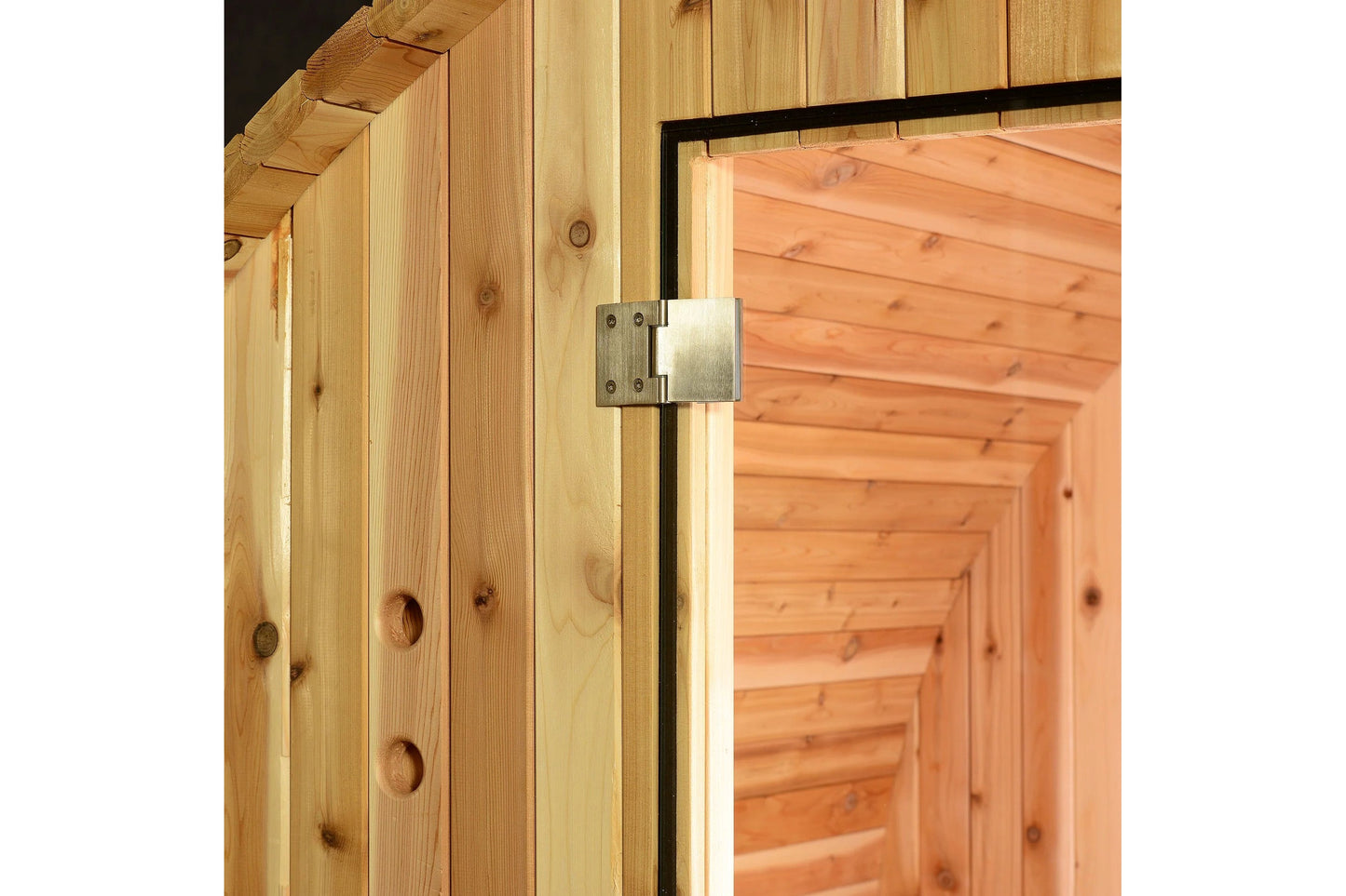 Natural pine wood sauna exterior with metal hinge detail on cedar door frame