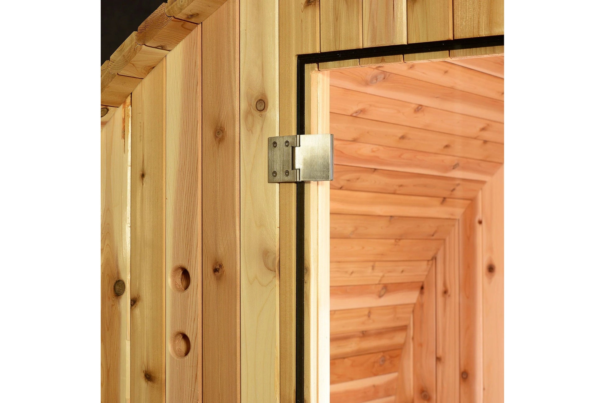 Natural pine wood sauna exterior with metal hinge detail on cedar door frame