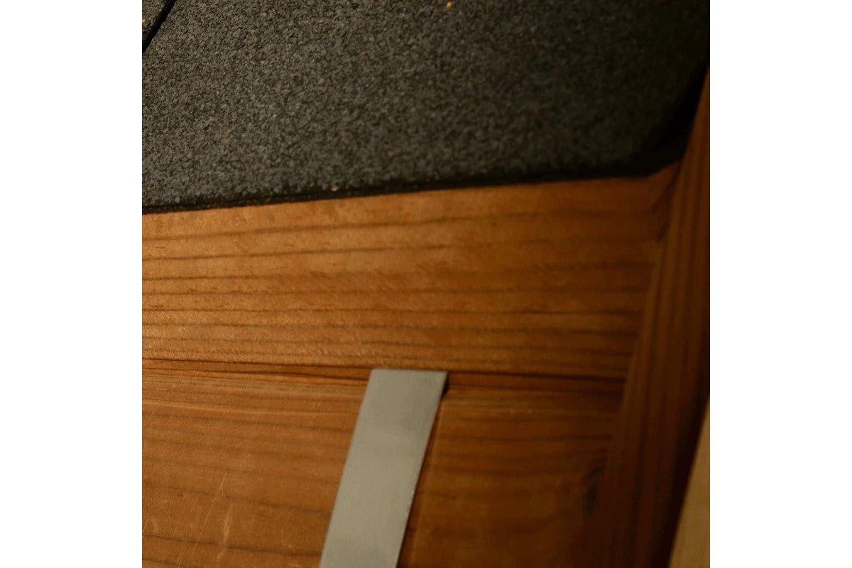 Charcoal gray wool exterior meets natural wood frame detail on barrel sauna construction