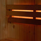 Almost Heaven Grayson hybrid sauna interior with wooden benches, dark stained backrest, and amber lighting on white backgroun