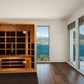 Almost Heaven Harmony infrared sauna with light wood exterior, glass front doors, and black interior panels in modern room wi