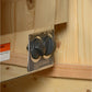 Black and tan wireless headphones displayed on product packaging box, wooden sauna interior background