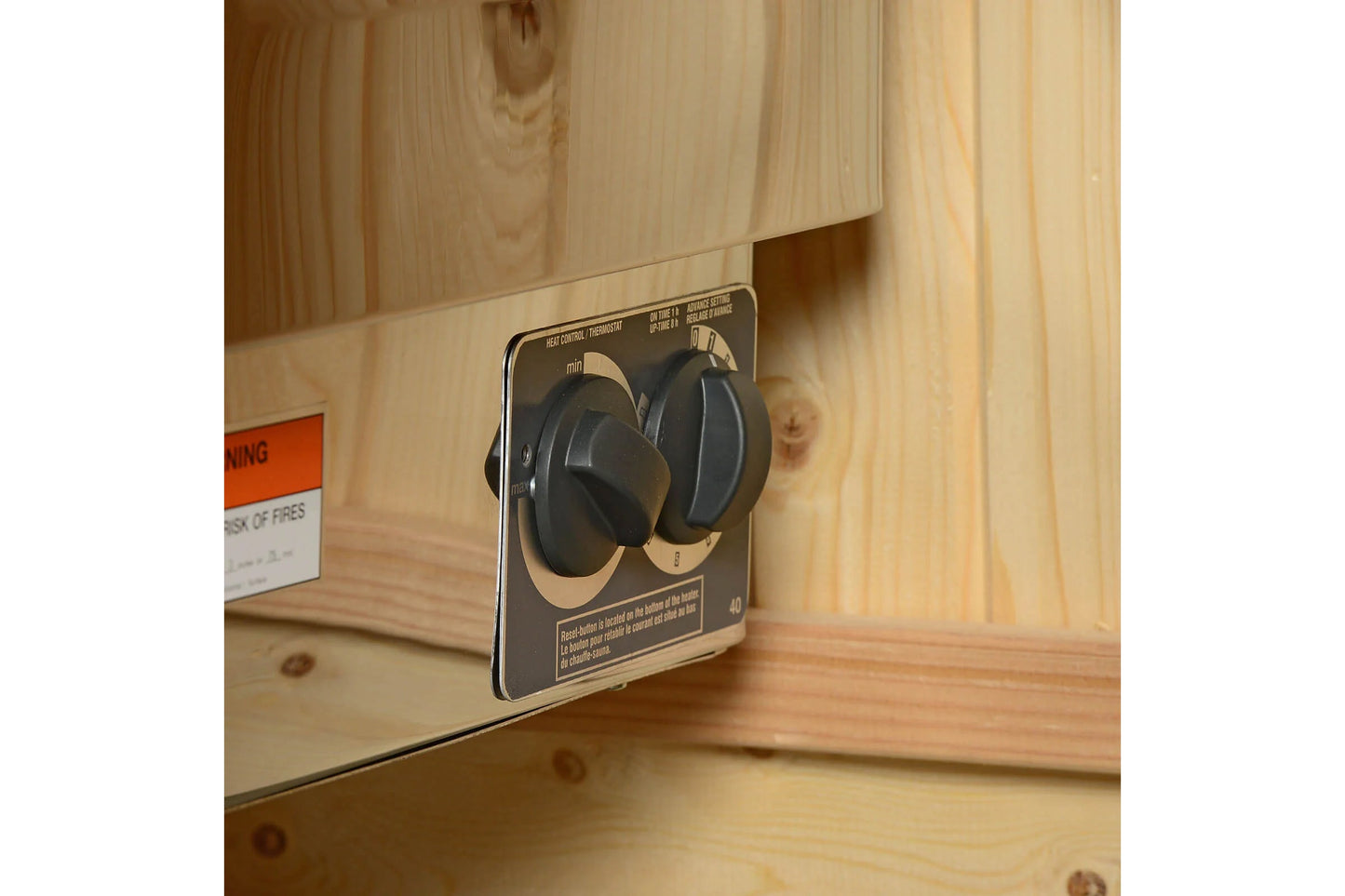 Black and tan wireless headphones displayed on product packaging box, wooden sauna interior background