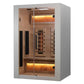 White and light wood infrared sauna with glass doors, cedar interior, warm amber lighting, and infrared heater panels visible