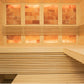 Interior view of wooden sauna with light pine walls, built-in benches, and salt brick windows glowing warm orange