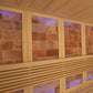 Interior of wooden sauna with light wood paneling, red salt brick walls backlit with blue and purple lighting, and wooden ben