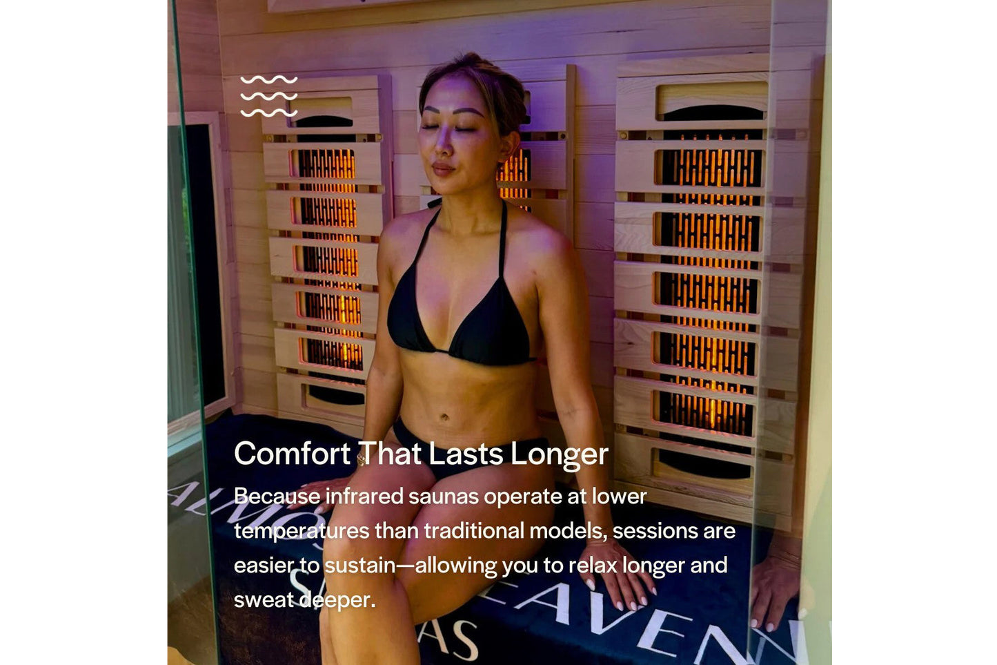 Woman wearing black triangle bikini inside infrared sauna with wooden walls and glowing heating panels