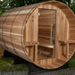 Wooden barrel sauna with cedar construction, open glass door, benches visible inside, metal bands around exterior, on black m