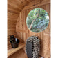 Wood barrel sauna interior with round window, black heater stove filled with stones, and wooden benches
