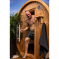Man exiting wooden barrel sauna with arched roof, round ventilation window, and black towel hanging outside