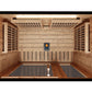 Interior overhead view of wood-paneled infrared sauna with benches, heating panels, control panel, and LED lighting