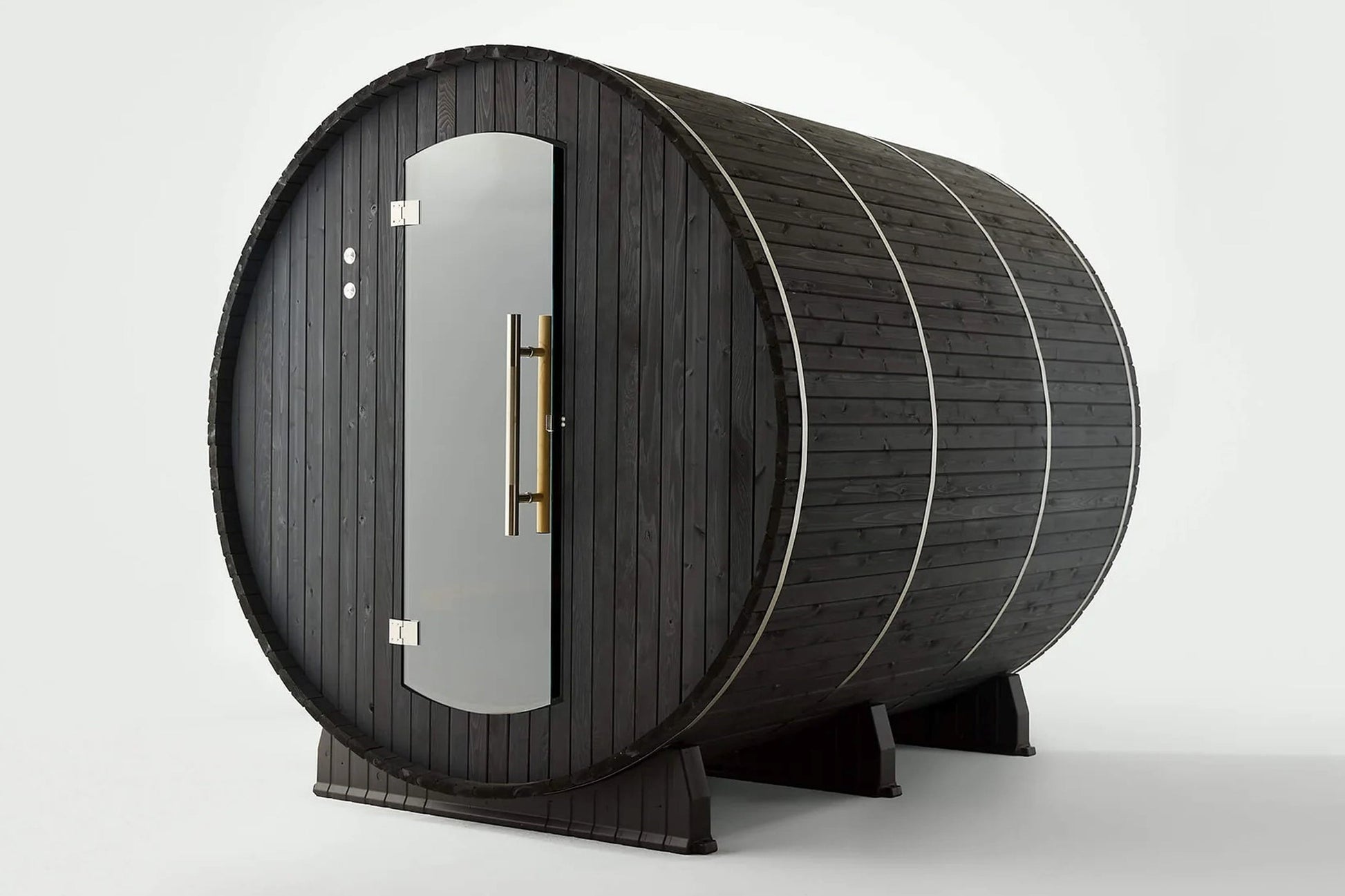 Black wood barrel sauna with glass door, brass handles, and metal bands, viewed on white background