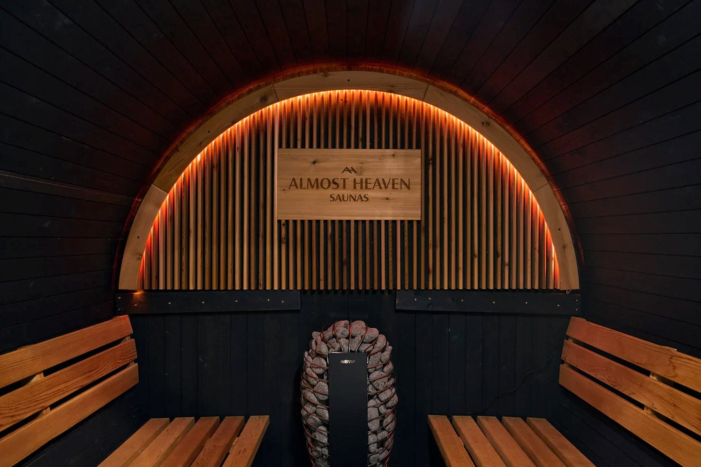 Modern barrel sauna interior with wooden benches on sides, arched wooden ceiling with vertical slats, orange neon lighting, s