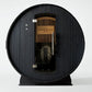 Black barrel sauna with wood interior, "Almost Heaven Saunas" branding, metal door, and visible heater stones on white backgr
