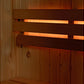 Almost Heaven Logan sauna interior with cedar wood walls, dark wood benches with integrated lighting strips, and warm amber b