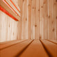 Almost Heaven Logan indoor sauna interior with light wood walls and bench seating, viewed from inside looking toward red door