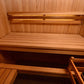 Cedar wood sauna interior with tiered seating benches and backrest mounted on wooden walls