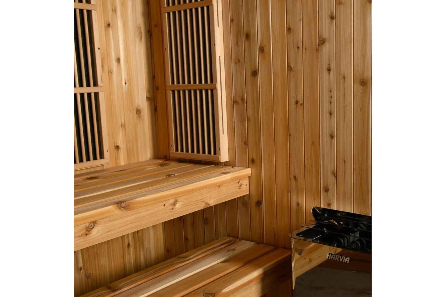 Cedar wood hybrid sauna interior with vertical shiplap walls, wooden benches with knots, slatted vents, and Harvia heater vis