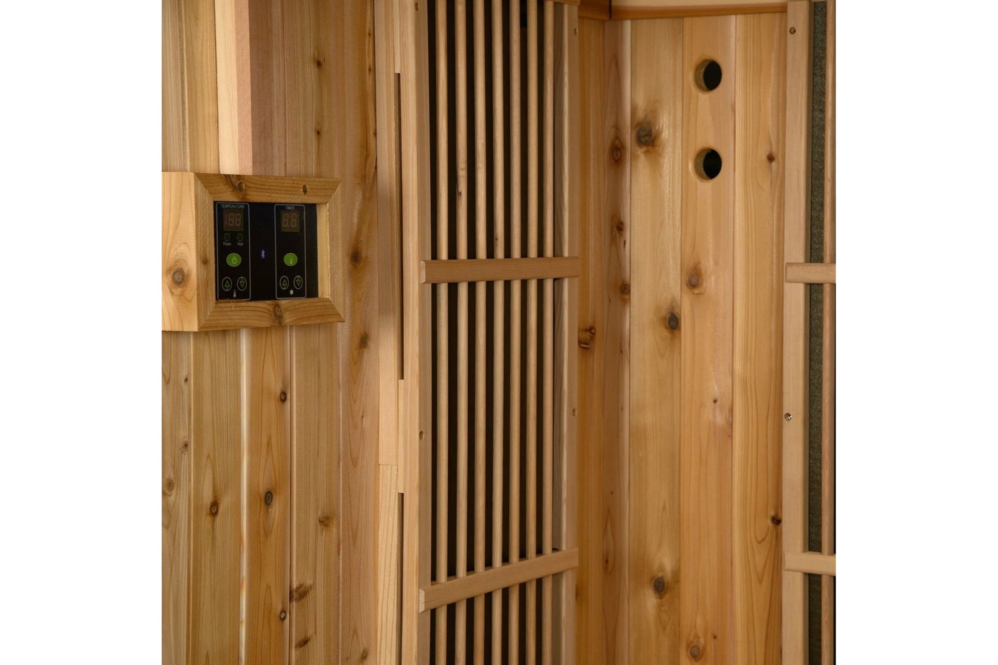 Cedar wood sauna interior with dual digital temperature controls, ventilation slats, and two circular air vents on the right 
