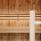 Interior view of wood sauna cabin with vertical cedar paneling, horizontal bench seating, and warm lighting on beige backgrou