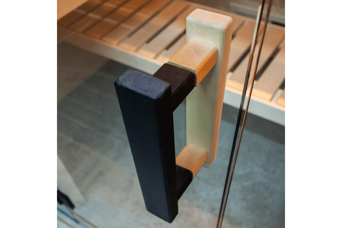 Nordik indoor sauna door handle with black metal pull and natural wood accents mounted on glass door